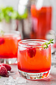 Red refreshing cold raspberry lemonade with ice and berries