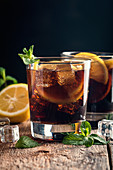 Fresh made Cuba Libre with brown rum, cola, mint and lemon