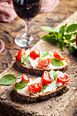 Crostini appetizers with cherry tomatoes, basil, and cheese