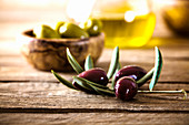 Wooden table with olives and olive oil