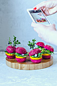 Mini vegan burgers with beetroot, carrots and lettuce being photographed