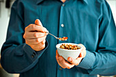 Hands holding a bowl with muesli