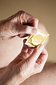 Close-up of elderly woman holding condom
