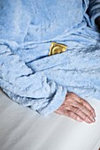 Close-up of elderly woman with condom in dressing gown