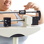 Overweight woman using weighing scales