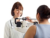 Doctor weighing woman on scales
