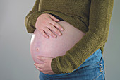 Pregnant woman with hands on abdomen