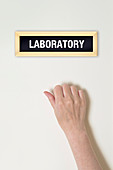 Female hand knocking on laboratory door