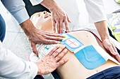 First-aider placing defibrillator pads