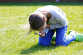 Girl examining grass