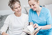 Carer reading book with woman