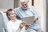 Senior couple in hospital room with tablet