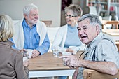 Friends talking and smiling in retirement home