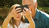 Elderly man and girl take selfie