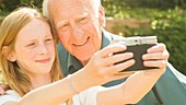 Elderly man and girl take selfie