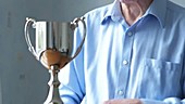 Elderly man polishing trophy