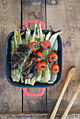 Baked celery stalks with grilled tomatoes and crispy bacon
