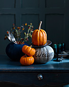 Decorative pumpkins with cutlery, flowers, and glasses of wines
