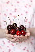 A girl holding cherries