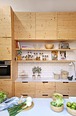 Schlichte Küche mit Naturholzfronten und offenen Regalen