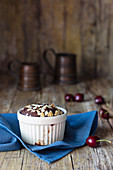 Schokoladenmuffin mit Kirschen und Mandeln in Porzellanförmchen