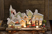 Beleuchtetes Weihnachtsdorf mit pastellfarbenen Papphäusern