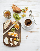 Brie cheese and fig jam sandwiches with fresh grapes and ground cherries
