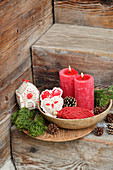 Gehäkelte Weihnachtsdekoration und rote Kerzen auf rustikaler Holztreppe
