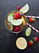 A tall glass of Pimms with lime and raspberry