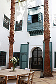 Round table with stone top and chairs in lobby of the Hotel Ryad Dyor (Marrakesh, Morocco)