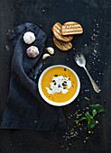 Pumpkin soup with cream, seeds, bread and fresh basil