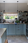 Blue base cabinets and vintage pendant lamps in kitchen