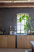 Base cabinet with wooden doors in kitchen with dark grey walls