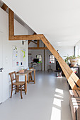 Console table and chair in open-plan attic room with white floor