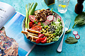 Salad Bowl mit Gurke, dicken Bohnen, Radieschen, Blumenkohl, Pastinaken, Paprika, Spinat und Frühlingszwiebeln