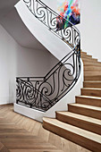 Wooden stairs and curved, wrought-iron banisters in the stairwell