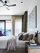 Doppelbett mit Kissensammlung im Schlafzimmer mit Balkon