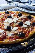 A tomato tart with shaved Parmesan and olives