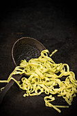 Herb tagliatelle on an old draining spoon