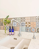 Sink with splashback of Mediterranean-style patterned tiles