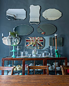 Collection of old mirrors above crockery in display cabinet
