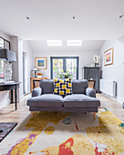 Colourful scatter cushion on grey sofa in classic living room