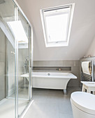 Free-standing modern bathtub in bathroom with sloping ceiling