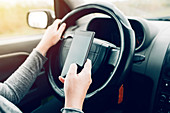 Woman driving and using smartphone