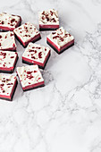 Red Velvet cheesecake brownies on a marble surface