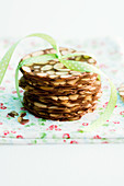 A stack of flaked almond biscuits with ribbon