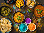 Klassische indische Gerichte zum Holi-Fest serviert mit Holipulver