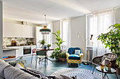 Weiße Küche, Essbereich und Lounge in offenem Wohnraum mit blauem Fliesenboden