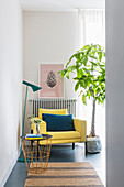 Side table, standard lamp, yellow armchair and potted tree in corner of room