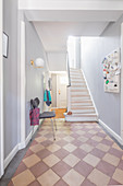 Chequered floor and staircase in bright hallway